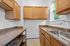 Charming kitchen with modern wooden cabinets, ample countertop space, and a bright window view.