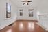 Bright and inviting room with hardwood floors, elegant white trim, and a decorative fireplace, perfect for cozy modern living.