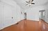 Bright and airy room with classic white walls, elegant ceiling fan, and warm wooden floors, perfect for versatile interior design.