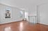 Charming room with polished wood floors, a decorative fireplace, and ample natural light from two large windows.