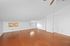 Bright attic space with natural light, wood floors, and white brick accents.