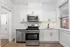 Modern kitchen with sleek stainless steel appliances, white cabinetry, and elegant countertops in a bright space.
