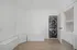 Bright and modern laundry alcove featuring a sleek stacked washer and dryer, complemented by built-in corner bench seating, perfect for organizing and relaxing.