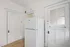 Bright kitchen corner featuring a modern refrigerator, hardwood floor, and charming vintage-style doors.