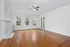 Bright and airy living room with elegant hardwood floors, pristine white walls, and a charming fireplace, perfect for cozy evenings.