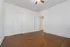 Bright, spacious room with pristine white walls, elegant hardwood flooring, and ceiling fan, perfect for a cozy bedroom or inspiring home office setup.