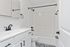 Elegant bathroom with sleek white cabinetry, stylish black fixtures, and a sophisticated patterned floor.