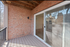 Charming balcony with brick walls and sliding glass doors, perfect for relaxing and enjoying outdoor views.