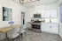 Modern kitchen with sleek white cabinets, stainless steel appliances, and a stylish dining area.