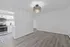 Bright and modern living area with stylish chandelier and sleek hardwood floors, adjacent to a fully equipped kitchen with contemporary appliances and chic tile flooring.