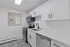 Modern kitchen with sleek white cabinetry, stainless steel appliances, and artistic tiled flooring for a contemporary touch.