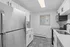 Modern kitchen with sleek stainless steel appliances, elegant white cabinetry, and patterned tile flooring.