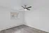 Bright and modern bedroom with hardwood floors, natural light, and a sleek ceiling fan.
