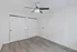 Bright and modern bedroom with sleek ceiling fan, ample closet space, and elegant wood flooring.