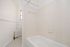 Bright bathroom featuring classic white tiles and elegant black-and-white patterned flooring.