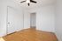 Bright, minimalist room with hardwood floors and modern ceiling fan, perfect for a cozy bedroom or office space.