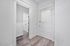 Bright hallway with modern wooden flooring and classic white doors, offering a welcoming entrance to a stylish apartment.