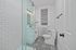 Chic bathroom featuring intricate tile flooring, a sleek glass shower, and contemporary lighting.
