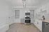 Bright modern kitchen with sleek stainless steel appliances, elegant cabinetry, and stylish light fixture, offering a welcoming and functional cooking space.