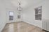 Bright, airy room with elegant lighting, large windows, and sleek hardwood flooring.