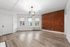 Bright and airy living space with modern lighting, exposed brick wall, and elegant hardwood flooring.