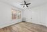 Bright and airy room featuring elegant hardwood floors, a sleek ceiling fan, and large windows offering plenty of natural light.
