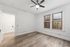 Bright and airy room featuring elegant hardwood floors, large windows with a view, and a ceiling fan for comfort.