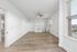 Bright, spacious living room with elegant wood flooring, a modern ceiling fan, and large windows for ample natural light.