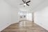 Bright, airy room with elegant hardwood flooring, a ceiling fan, and large bay windows offering scenic views.