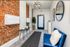 Chic apartment lobby with exposed brick walls, stylish lighting, and modern decor.