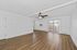 Bright, spacious living room with elegant wood flooring, modern ceiling fan, and large sliding glass doors leading to a balcony.
