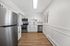 Modern kitchen featuring sleek stainless steel appliances, elegant white cabinetry, and warm wooden flooring.