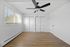 Bright and spacious empty bedroom featuring elegant hardwood floors, a sleek ceiling fan, and large window with blinds for natural light.