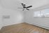 Bright and airy bedroom with modern ceiling fan, sleek blinds, and elegant wooden floors.