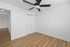 Bright room with elegant wood flooring, sleek ceiling fan, and modern closet doors.