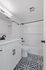 Chic modern bathroom with elegant black and white patterned tiles, a sleek white vanity, and contemporary fixtures.