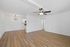 Bright, open-concept living space with elegant wood flooring, a modern kitchen, and stylish light fixtures, ideal for comfortable living.