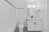 Elegant bathroom with modern fixtures, pristine white walls, and stylish patterned floor tiles.