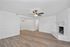Charming living room with elegant wood flooring, a classic white brick fireplace, and a modern ceiling fan above.