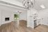 Elegant open-concept apartment featuring a modern kitchen with stainless steel appliances, spacious living area with fireplace, and beautiful hardwood floors.