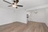 Bright and modern open-plan living room with elegant light fixtures, hardwood floors, and a peek into a sleek kitchen.