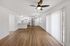Modern open-concept apartment with spacious living area, sleek wood flooring, and a bright kitchen featuring stainless steel appliances.