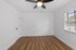 Bright and inviting room with sleek hardwood flooring, a stylish ceiling fan, and abundant natural light from the window.