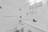 Modern and bright bathroom with sleek white tiles, elegant fixtures, and a spacious vanity.