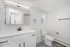 Bright, contemporary bathroom with sleek mirror cabinets, elegant fixtures, and patterned floor tiles.
