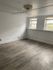 Bright, spacious room featuring elegant wood flooring and charming double windows.
