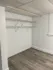 Spacious walk-in closet with modern shelving and beautiful wood flooring, perfect for ample storage and organization.