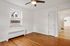 Bright room with polished hardwood floors, a large window allowing natural light, and a modern ceiling fan.