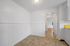 Bright space with elegant archway, crisp white walls, and charming tile flooring leading to an inviting, sunlit room.