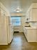 Bright, modern kitchen with clean white cabinetry and sleek appliances, offering a cozy and functional cooking space.